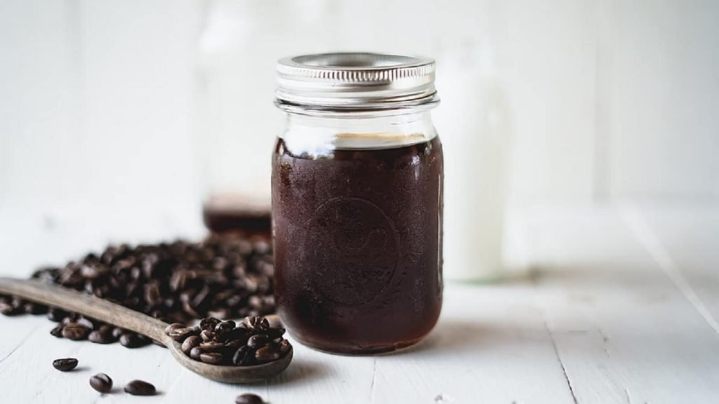 Secangkir kopi dingin di atas biji kopi panggang